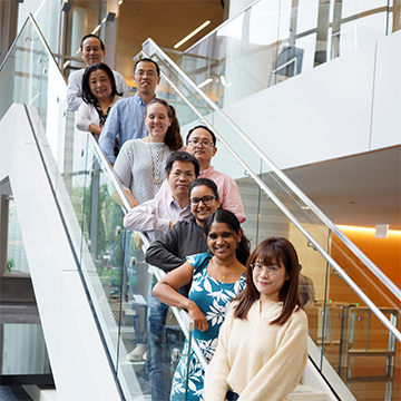 Lab members pose along a staircase