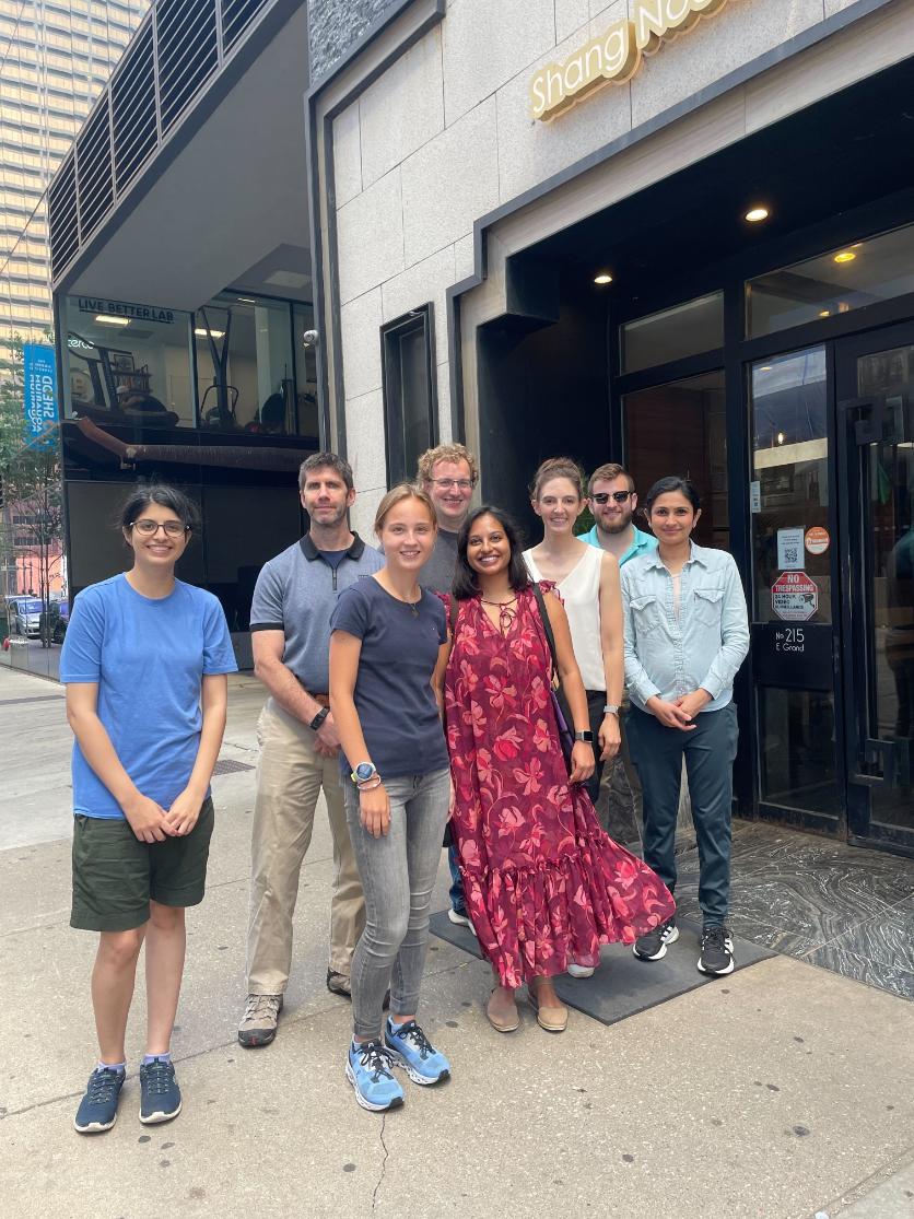 Members posing outside a restaurant